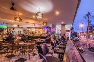 un restaurante con sillas y mesas y un bar en Sutus Court 4, en Pattaya central