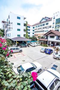 a parking lot with cars parked in front of a building at Sutus Court 4 in Pattaya