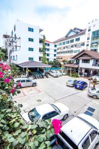 un parking avec des voitures garées devant un bâtiment dans l'établissement Sutus Court 4, à Pattaya