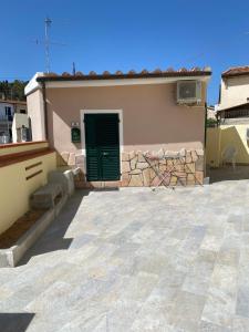 a house with a green door and a patio at MONOVAPELO in Marina di Campo
