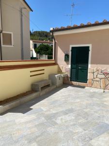 ein Haus mit einer grünen Tür und einer Terrasse in der Unterkunft MONOVAPELO in Marina di Campo