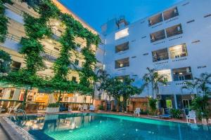 a swimming pool in front of a building at Sutus Court 4 in Pattaya