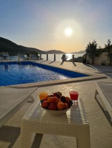 a bowl of fruit on a table next to a pool at Apartmani Barka in Neum