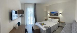 um quarto branco com uma cama e uma janela em Calafato Guest House em Favignana