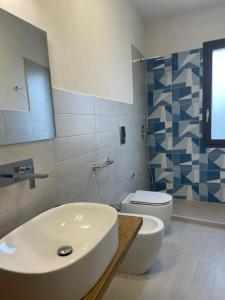 a bathroom with a white sink and a toilet at Calafato Guest House in Favignana