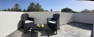 2 Stühle und ein Tisch auf der Terrasse in der Unterkunft Calafato Guest House in Favignana