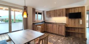 a kitchen with wooden cabinets and a table with a television at Mittelbergerhof Ferienwohnungen in Vilpiano