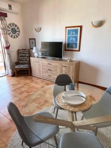 ein Wohnzimmer mit einem Tisch und Stühlen sowie einem TV in der Unterkunft Apartment Los Gigantes  in Acantilado de los Gigantes
