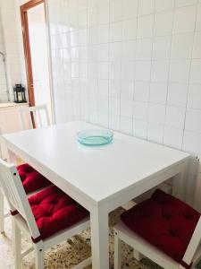 a white table with two chairs and a plate on it at Casa CHORIMA in Arzúa