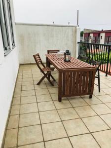 una mesa de madera y 2 sillas en el patio en Casa CHORIMA, en Arzúa