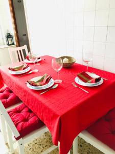 einen roten Tisch mit Weingläsern und Tafeln darauf in der Unterkunft Casa CHORIMA in Arzúa