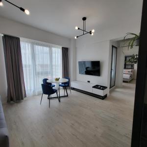 コンスタンツァにあるKuuB Apartmentsのテーブルと椅子とテレビのあるリビングルーム +30枚の写真