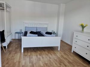 un letto bianco con cuscini sopra di Ferienwohnung Sonnenberg an der Weinstraße a Leinsweiler