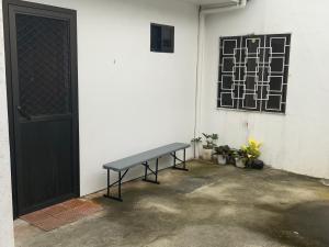 a bench sitting next to a building with a door at Chillax Inn in Tagaytay