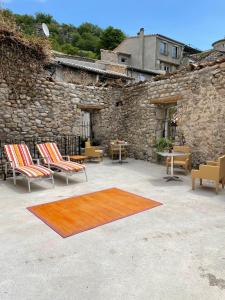 un patio con sillas, una mesa y una alfombra en La Secrète, en Vogüé