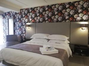 a bedroom with two beds and a wall with flowers at d Olive Rose Boutique Hotel Danielskuil in Daniëlskuil +34 photos