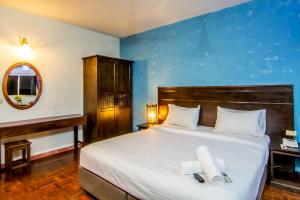 une chambre avec un grand lit avec un mur bleu dans l'établissement Sutus Court 2, à Pattaya 29 autres photos