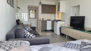 uma sala de estar com um sofá e uma cozinha em Apartment LOTI em Piran