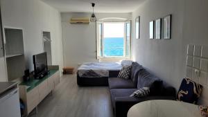 uma sala de estar com um sofá, uma cama e uma janela em Apartment LOTI em Piran