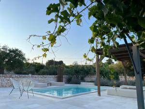 a swimming pool in a backyard with a stone wall at Trullo Matilde in Martina Franca