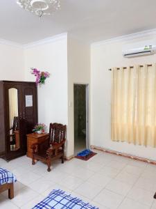 uma sala de estar com uma cadeira e uma janela em Quang Diep Motel em Vung Tau