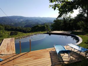 a swimming pool with two chairs and a wooden deck at Holiday Home Sonnenhaus in Svečina