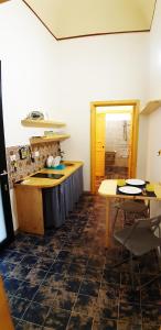 a kitchen with a sink and a table and a counter at Case Vacanze "Residenze Trapanesi" in Trapani