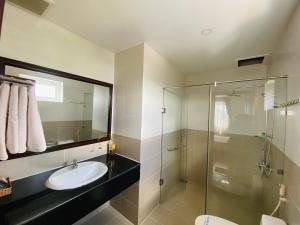 uma casa de banho com um lavatório e uma cabina de duche em vidro. em Hotel Mỹ Mỹ em Tây Ninh