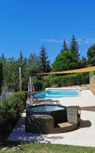 a swimming pool with two wicker chairs next to it at Aux chataigniers alpins in Gap