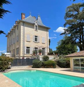 ein großes Haus mit Pool davor in der Unterkunft Appartement de charme dans château du XIXème in Lentilly