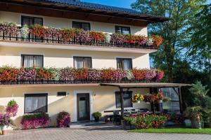 un edificio con flores en los balcones en Erlebnisbauernhof Pension Waschnig, en Sankt Kanzian