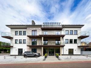 a building with a car parked in front of it at Villa Continental in Pobierowo