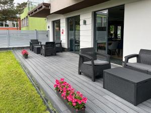 una terraza con sillas y flores en una casa en Villa Continental en Pobierowo