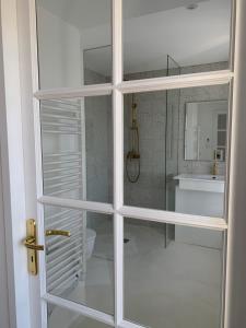 a bathroom with a toilet and a glass door at La Rose du Cèdre in Gray