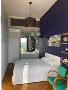 ein Schlafzimmer mit einem weißen Bett und einer lila Wand in der Unterkunft Appartement de charme dans château du XIXème in Lentilly