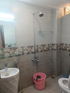 a bathroom with a shower and a sink and a bucket at City Seasons Hotel Murree in Murree