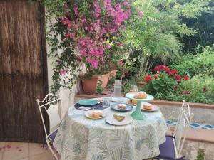 a table with plates of food on it with flowers at B&B Casa Chinaski in Mondello