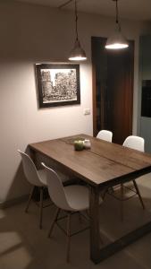 a dining room table with white chairs around it at Appartamento Dellantonio in Predazzo