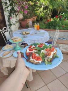 a person holding a plate of food on a table at B&B Casa Chinaski in Mondello
