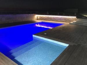 uma grande piscina com água azul à noite em Panoramic Beachfront Villa - Direct Beach Access em Esposende