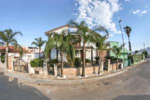 una casa con palme di fronte a una strada di Blue And Blue City a Ugento
