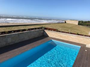 uma piscina com vista para o oceano em Panoramic Beachfront Villa - Direct Beach Access em Esposende