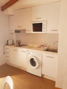 een witte keuken met een wasmachine bij Segunda casa de Ana Lucia en la playa in Villajoyosa