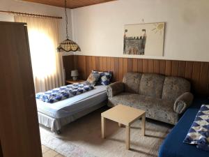 Sala de estar con cama, sofá y mesa en Haus Porta, en Porta Westfalica