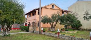 a pink house with trees in front of it at Anna Garden Sidari in Sidari