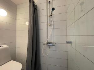 uma casa de banho com uma cabeça de chuveiro em BORG Sommerhotell em Spjelkavik