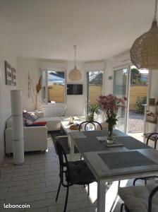 un soggiorno con tavolo, sedie e divano di Maison tout confort au calme à 300m de la mer et du GR34 avec jardin a Loctudy