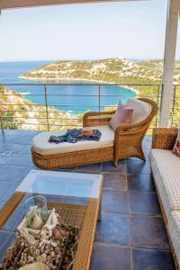 a balcony with a couch and a table and the ocean at Oasis Resort in Pefkali