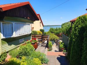 a house with a patio with a view of the water at Juno Holiday in Mrągowo