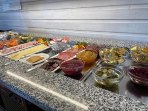 a counter with many different bowls of food on it at BORG Sommerhotell in Spjelkavik